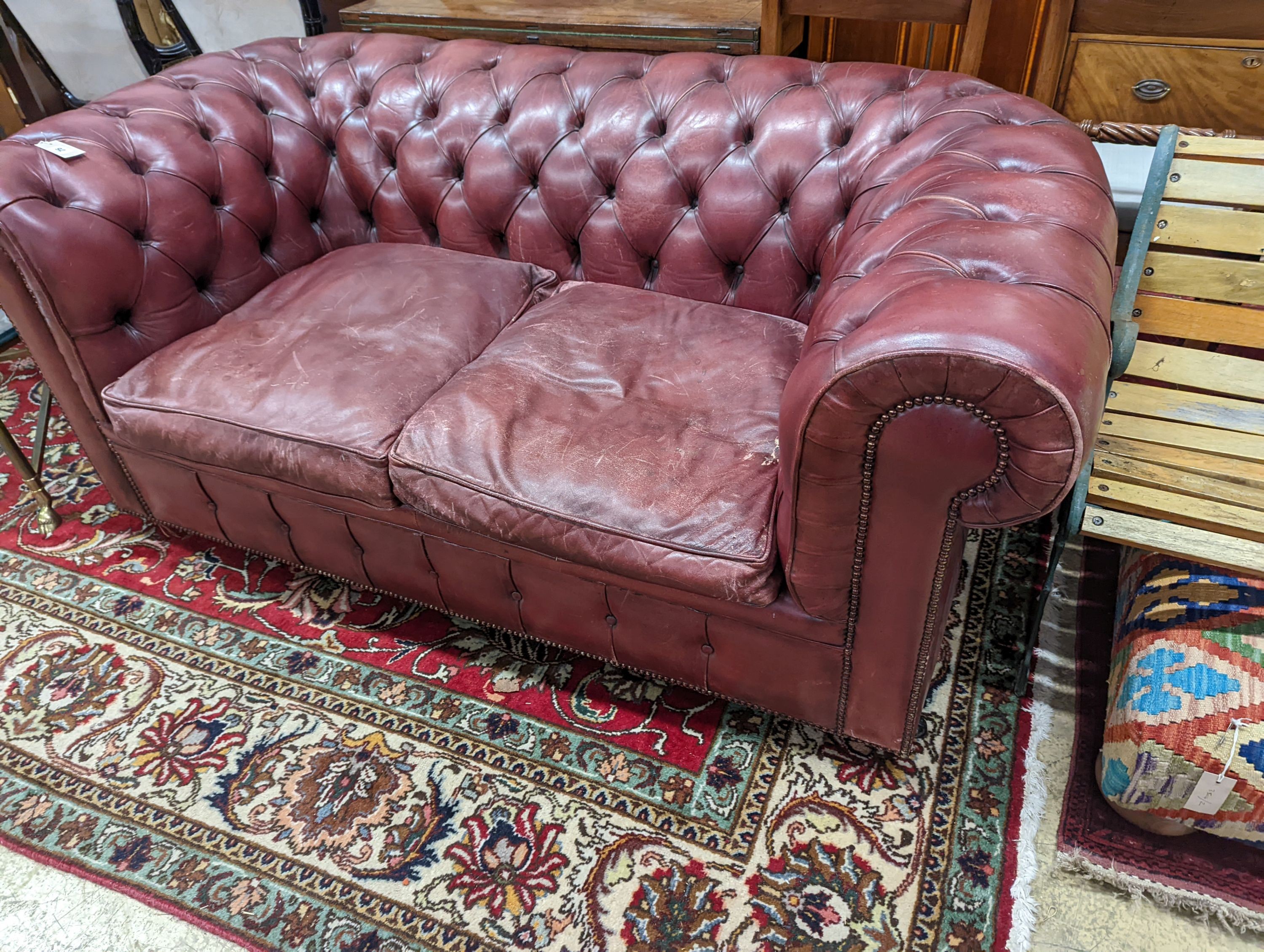A Victorian style buttoned burgundy leather Chesterfield settee, length 172cm, depth 90cm, height 73cm
